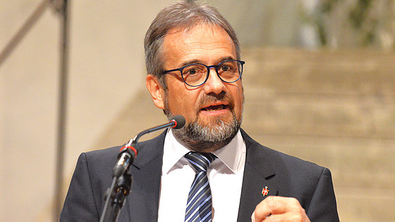 Das Bild zeigt Bischof Harald Rückert in engagierter Körperhaltung beim Predigen. Sein Mund ist beim Reden leicht geöffnet und die Augen schauen zielgerichtet ins Publikum leicht rechts vom Betrachter.