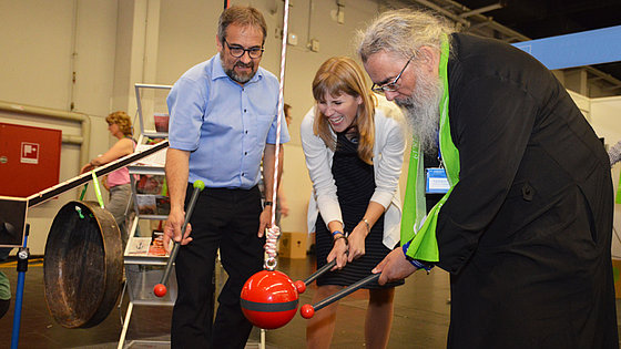 Die Aktion am EmK-Stand beim Kirchentag in Dortmund machte mit Magneten unsichtbare Kräfte sichtbar. Hier in ökumenischer Einheit aktiv (von links): Bischof Harald Rückert, Dr. Verena Hammes und Erzpriester Radu Constantin Miron