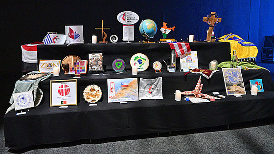 Etwa 30 Symbole stehen in drei stufenförmig angeordneten Reihen. Vertreten sind einige internationale Kirchen sowie Kirchen aus folgenden Ländern: Argentinien, Australien, Brasilien, Chile, Ghana, Hongkong, Indien, Italien, Portugal, Tonga und andere.