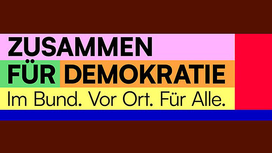 Auf einem vielfarbigen Hintergrund stehen folgende Wörter groß und fett: »Zusammen für Demokratie«. Etwas kleiner steht darunter: »Im Bund. Vor Ort. Für Alle.«