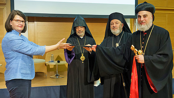 Einen schriftlichen Appell, die Lage der Christen im Nahen Osten ernst zu nehmen, übergeben Erzbischof Philoxenus Mattias Nayis, Metropolit Isaak Barakat und Bischof Serovpé Isakhanyan (v.r.n.l.) an Dr. Maria Flachsbarth (li.)