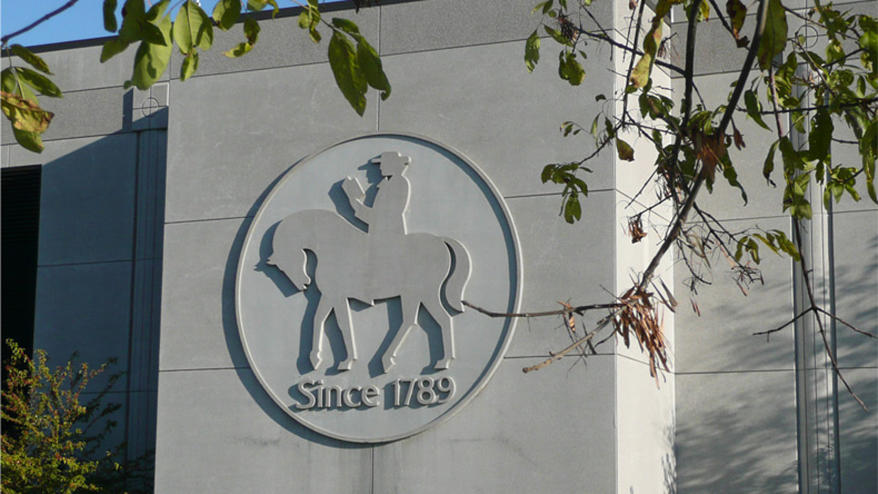 Außenaufnahme einer modernen Hauswand miteinem großen kreisförmigen Emblem. In der Mitte John Wesley auf einem Pferd sitzend. Darunter der Schriftzug: Since 1789