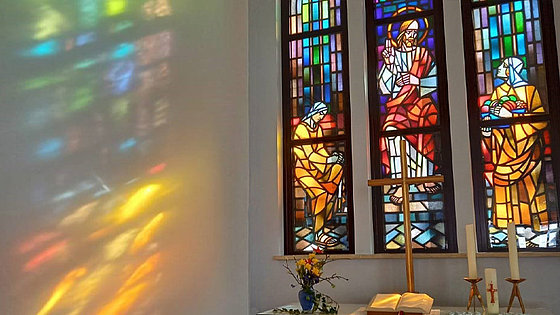Das farbenfrohe Fensterbild in der evangelisch-methodistischen Friedenskirche in Zwickau zeigt Jesus zwischen der hörenden Maria und der agierenden Marta.