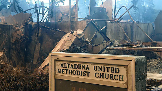 Im Hintergrund sind Schutt, Trümmer und verbogener Stahl. Im Vordergrund ist das Hinweisschild mit dem Namen der Gemeinde: Altadena United Methodist Church.