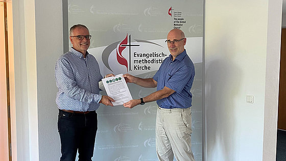 Ein Vertreter der Gruppe »Christians for Future« überreicht dem Leiter der Kirchenkanzlei der Evangelisch-methodistischen Kirche in Frankfurt die Forderungen der christlichen Klimaaktivisten.
