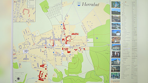 Ortskarte der Herrnhuter Siedlung: Waagerecht quert die Hauptstraße den Ort. Rechts und links zweigen Ortsstraßen ab. Rot hervorgehoben sind geschichtlich wichtige Gebäude der Brüdergemeine, die an der rechten Seite in einer Legende erklärt werden.