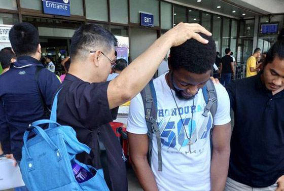 Auf dem Flughafen in Manila bittet Bischof  Ciriaco Francisco Gott um seinen Segen für den jungen Missionar Tawanda Chandiwana.