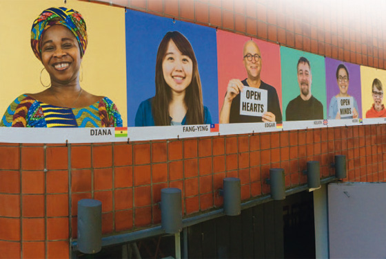 Ein buntes Banner mit vielen Gesichtern von Menschen aus aller Welt schmückt die EmK-Gemeinde Hamburg-International. Das alte Gebäude wird dadurch von Menschen des Stadtteils fast als Neubau wahrgenommen.