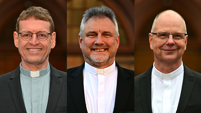 Links Kettner: bartlos, Brille, graues Kollarhemd, braune Haare, schlank. Mitte Philipp: Oberlippen- und Kinnbart, ohne Brille, graumelliertes Haar, weißes Kollarhemd. Rechts Rüdiger: bartlos, Brille, weißes Kollarhemd, Stirnglatze. Alle lächeln freundlich.