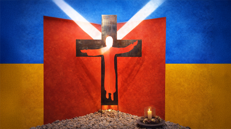 Kreuz mit Christusfigur vor der ukrainischen Flagge im einfallenden Sonnenlicht. Dazu eine brennende Kerze.